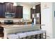 Kitchen island with breakfast bar, dark wood cabinets, and stainless steel appliances at 9004 Majesty Palm Rd, Kissimmee, FL 34747