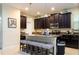 Kitchen island with breakfast bar, dark wood cabinets, and stainless steel appliances at 9004 Majesty Palm Rd, Kissimmee, FL 34747