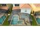 Aerial view of a screened-in pool and spa surrounded by patio furniture and well-maintained landscaping at 9004 Majesty Palm Rd, Kissimmee, FL 34747