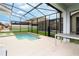 Screened-in pool and spa area with patio space for entertaining and a view of neighboring homes at 9004 Majesty Palm Rd, Kissimmee, FL 34747