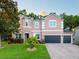 Charming two-story home boasts a well-maintained lawn, lush landscaping, and a three-car garage at 925 Counts Crest Cir, Apopka, FL 32712