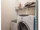 Clean laundry room with white washer and dryer with storage shelf at 925 Counts Crest Cir, Apopka, FL 32712