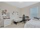 This bedroom has neutral colored carpet, two beds, and a desk near the window at 9456 Komika Ln, Winter Garden, FL 34787