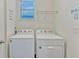 Bright laundry room features a modern washer and dryer, plus wall shelving at 9456 Komika Ln, Winter Garden, FL 34787