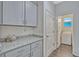 Laundry room with granite counters, ample cabinet space, and modern appliances at 9456 Komika Ln, Winter Garden, FL 34787
