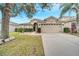 Charming single-story home with a spacious two-car garage, well-manicured lawn, and beautiful landscaping at 9736 Heron Pointe Dr, Orlando, FL 32832