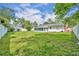 Expansive backyard featuring a well-maintained lawn, white fence, and a view of the rear of the home at 976 W Gaucho Cir, Deltona, FL 32725