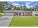 Charming single story red brick home with a well-manicured lawn and attached garage at 976 W Gaucho Cir, Deltona, FL 32725
