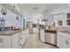 Spacious kitchen with a large island, granite countertops, white cabinetry, and stainless steel appliances at 976 W Gaucho Cir, Deltona, FL 32725