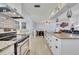 Open layout showcasing the kitchen flowing into the dining area with stainless steel appliances at 976 W Gaucho Cir, Deltona, FL 32725