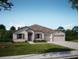 Charming single-story home boasts a well-manicured lawn, inviting facade, and a two car garage at Tbd Royal Trails Rd, Eustis, FL 32736