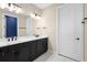 Stylish bathroom with dual sinks, dark cabinets, a large mirror, and modern lighting fixtures at 10215 Park Estates Ave, Orlando, FL 32836