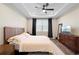 Bedroom with a ceiling fan, tray ceiling, dark curtains and wood-look floors at 10215 Park Estates Ave, Orlando, FL 32836