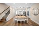 Open concept dining room with view into kitchen, featuring wood floors and staircase at 10215 Park Estates Ave, Orlando, FL 32836