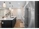 Bright kitchen features white cabinets, stainless steel appliances, an island with pendant lights, and wood floors at 10215 Park Estates Ave, Orlando, FL 32836