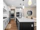 Modern kitchen featuring white cabinets, stainless steel appliances, an island and an adjacent laundry room at 10215 Park Estates Ave, Orlando, FL 32836