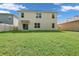 Large backyard with green grass, complemented by the home's exterior and neighboring fence for privacy at 1068 Brooklet Dr, Davenport, FL 33837