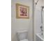 Clean bathroom with a white toilet, framed painting, and bathtub with shower at 1068 Brooklet Dr, Davenport, FL 33837