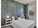 Inviting bedroom with a plush bed, blue accent wall with floral wallpaper, and bedside tables at 1068 Brooklet Dr, Davenport, FL 33837