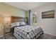 Bright bedroom featuring a plaid comforter, floral wallpaper, and natural light from a window at 1068 Brooklet Dr, Davenport, FL 33837