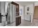 Contemporary kitchen with stainless steel refrigerator, dark cabinets, and tile flooring at 1068 Brooklet Dr, Davenport, FL 33837