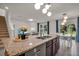 Open-concept kitchen with island seating, granite countertops, and stainless steel appliances at 1068 Brooklet Dr, Davenport, FL 33837