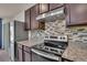 Modern kitchen featuring stainless steel appliances, granite countertops, and a stylish backsplash at 1068 Brooklet Dr, Davenport, FL 33837
