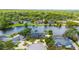 Scenic aerial view showcasing a lakefront property surrounded by lush trees and other homes in a quiet community at 107 Coveridge Ln, Longwood, FL 32779