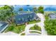 Stunning aerial view of a home with a large driveway, pool, screened enclosure, and lake access with a dock at 107 Coveridge Ln, Longwood, FL 32779