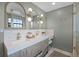 Bright bathroom with double vanity, unique light fixtures, and glass enclosed shower at 107 Coveridge Ln, Longwood, FL 32779