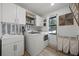 Bright laundry room featuring modern washer and dryer, stylish backsplash, and ample storage at 107 Coveridge Ln, Longwood, FL 32779