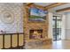 Close up on brick fireplace with mounted TV and sliding glass doors in the background at 107 Coveridge Ln, Longwood, FL 32779