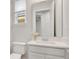 Bright half bathroom with white cabinets, stylish fixtures, and a large mirror at 1090 Wildmeadow Run, Winter Park, FL 32792