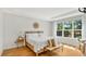 Bright bedroom featuring wood floors, a woven headboard, and an oversized window with a leafy view at 1090 Wildmeadow Run, Winter Park, FL 32792