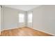Bedroom with neutral walls, wood floors, and bright natural light from two windows at 1090 Wildmeadow Run, Winter Park, FL 32792