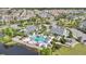 Aerial view of a community pool area with lounge chairs, lush landscaping, a playground, and ample parking at 1090 Wildmeadow Run, Winter Park, FL 32792