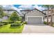 Charming two-story home with manicured lawn, paved driveway, and attached two-car garage at 1090 Wildmeadow Run, Winter Park, FL 32792