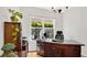 Well-lit home office features a large ornate desk, wood floors, and a bright window at 1090 Wildmeadow Run, Winter Park, FL 32792