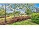 Scenic landscaping frames the well-maintained lawn, complete with trees, vibrant bushes, and a view of the neighborhood pond at 1090 Wildmeadow Run, Winter Park, FL 32792