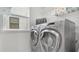 Convenient laundry room with modern washer and dryer, shelving, and natural light at 1090 Wildmeadow Run, Winter Park, FL 32792