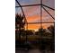 Beautiful screened patio view overlooking a tranquil pond surrounded by lush greenery under a vibrant sky at 1090 Wildmeadow Run, Winter Park, FL 32792