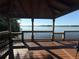 Stunning lake view from a covered wooden pavilion with dark wood ceiling and wood railing at 1090 Wildmeadow Run, Winter Park, FL 32792