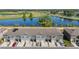 Aerial view showcasing townhomes, a pond, and the golf course in Ridgewood Lakes Del Webb community at 1121 Blue Jay Dr, Davenport, FL 33837