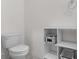 Clean, simple bathroom with white fixtures, storage shelves and decorative baskets at 1121 Blue Jay Dr, Davenport, FL 33837