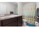 Bright bathroom featuring a vanity with granite countertop, decorative shower curtain, and tiled flooring at 1121 Blue Jay Dr, Davenport, FL 33837