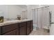 Well-lit bathroom with double sinks, granite countertops, and a patterned shower curtain at 1121 Blue Jay Dr, Davenport, FL 33837