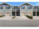 Charming townhomes featuring neutral exteriors, garages, and manicured landscaping under a clear blue sky at 1121 Blue Jay Dr, Davenport, FL 33837