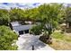 Stunning aerial shot of home with a long drive, mature trees, and a screened pool at 120 W Trade Winds Rd, Winter Springs, FL 32708