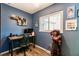 Bedroom with desk, blue walls, chandelier, and hardwood floors at 120 W Trade Winds Rd, Winter Springs, FL 32708