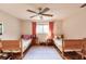 This charming bedroom features two twin beds, a ceiling fan, and hardwood-style flooring at 120 W Trade Winds Rd, Winter Springs, FL 32708